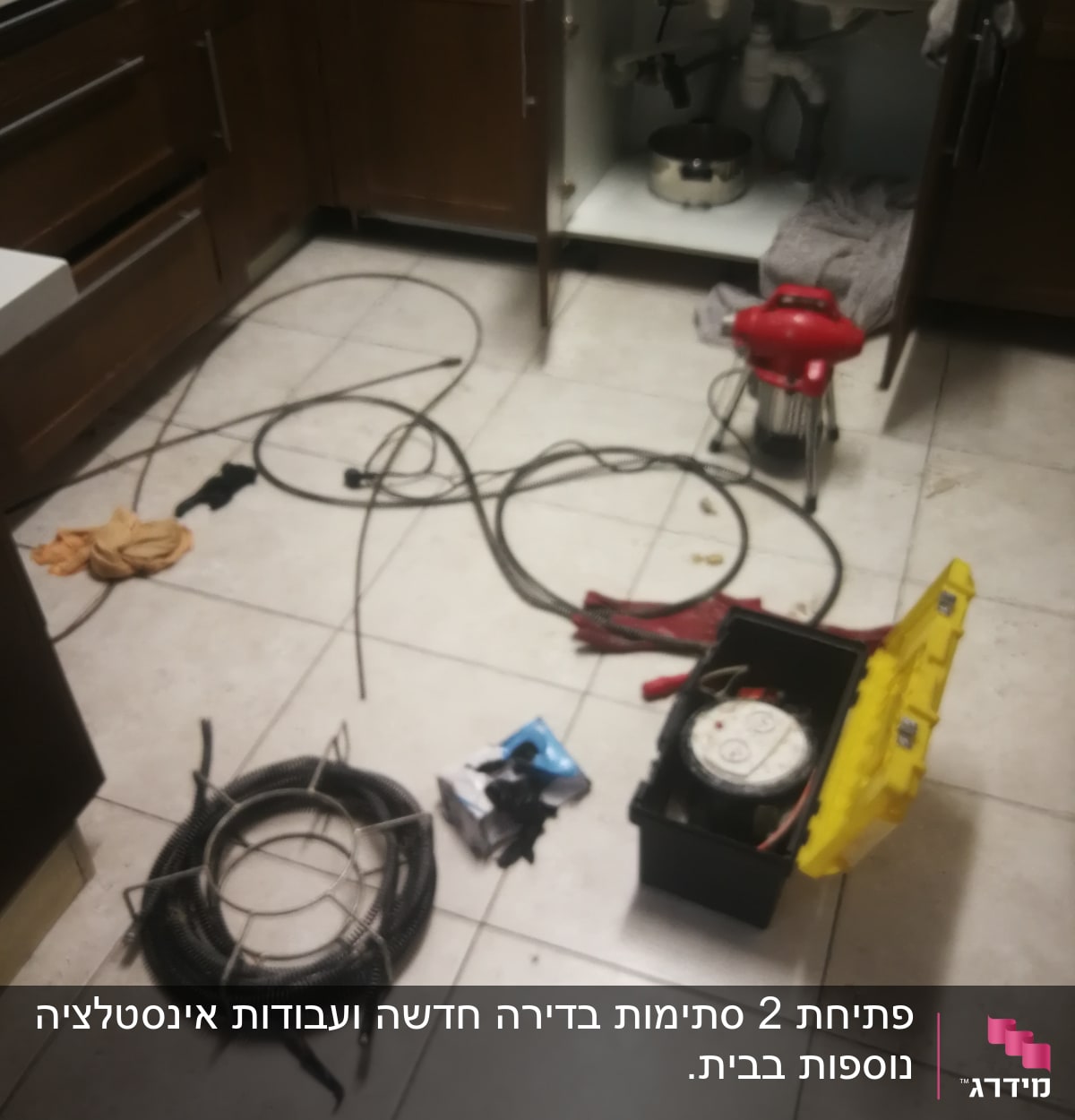 כלי עבודה של אינסטלטור מתחת לכיור במטבח